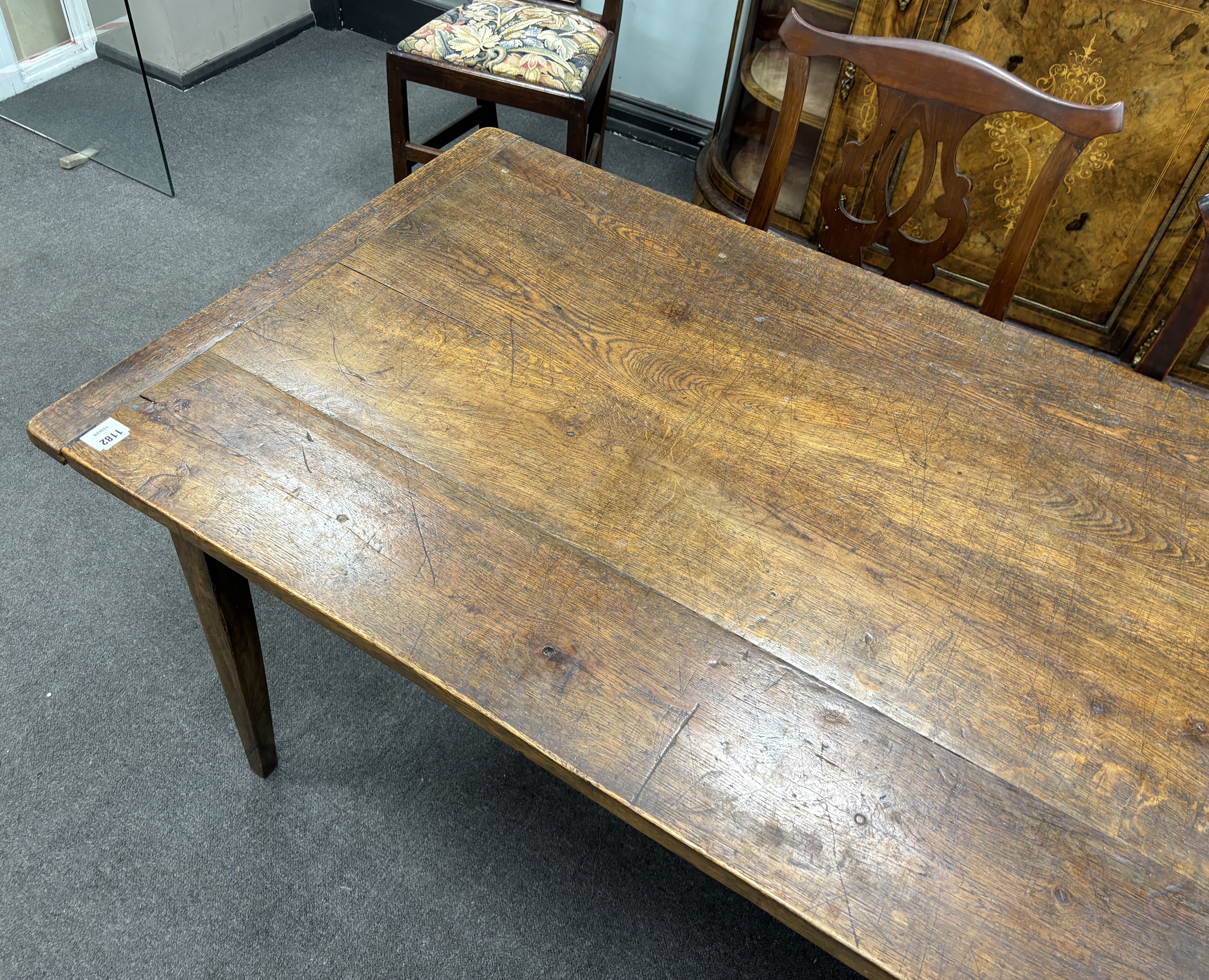 A 19th century rectangular Provincial oak kitchen table with cleated plank top, fitted two drawers on square tapered legs, width 220cm, depth 84cm, height 74cm